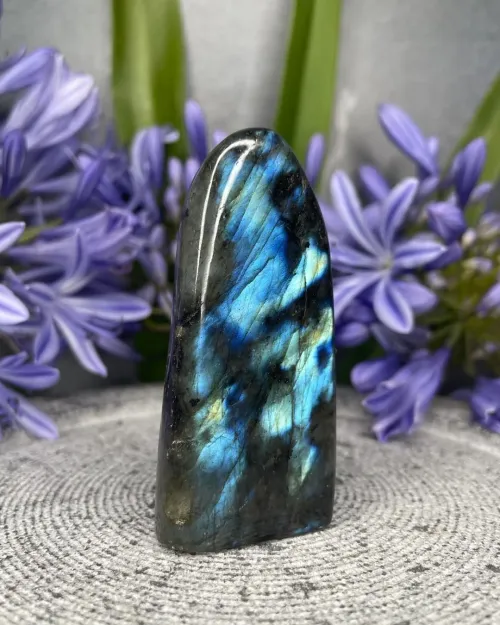 Hand holding labradorite tile showing multiple color angles