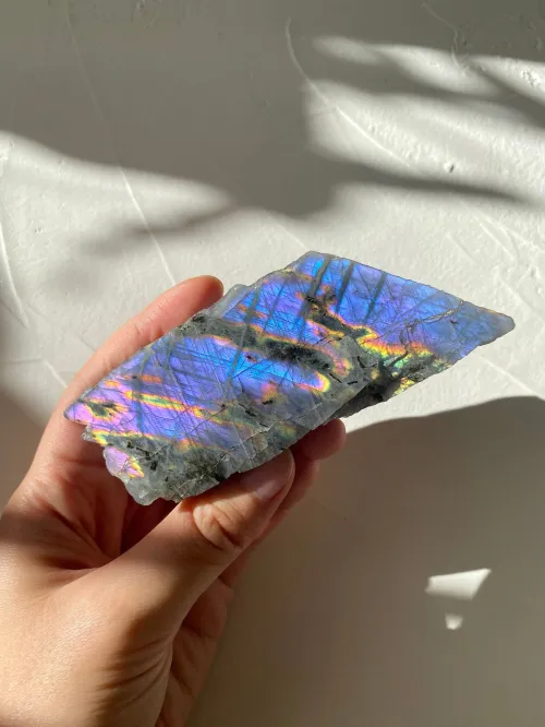 Person drying labradorite jewelry with microfiber cloth