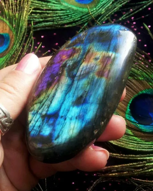 Person holding labradorite crystal during meditation for grounding and focus